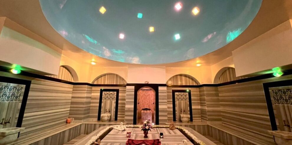 nterior view of a luxurious Turkish Bath (Hammam) in Hurghada featuring a warm marble stone (Gobek Tasi) and atmospheric lighting