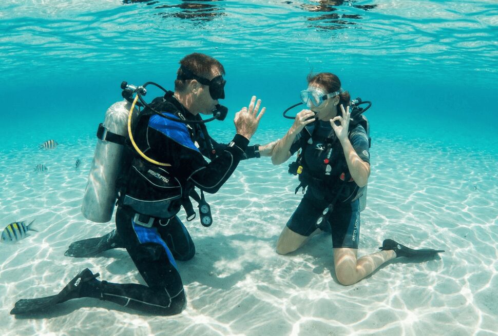 PADI instructor teaching a student scuba diving skills in Hurghada's clear shallow waters.